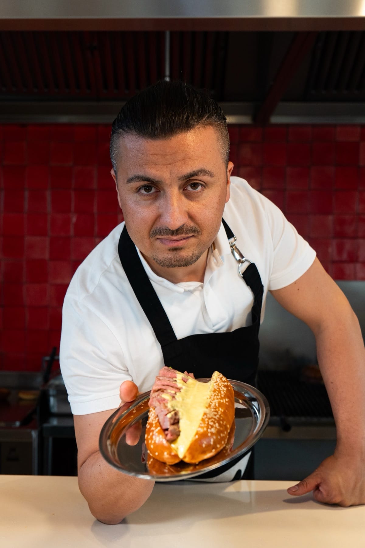 Burg'un mutfağında şef, tabakta bir sandviç